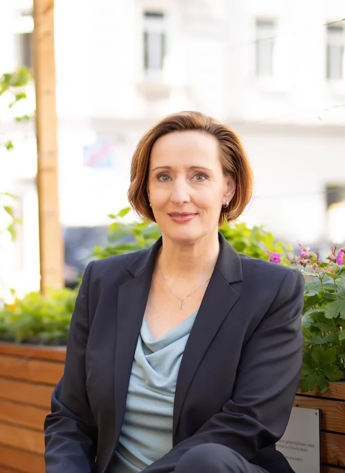 Hemma Bieser in einem blauen Sakko blickt in die Kamera